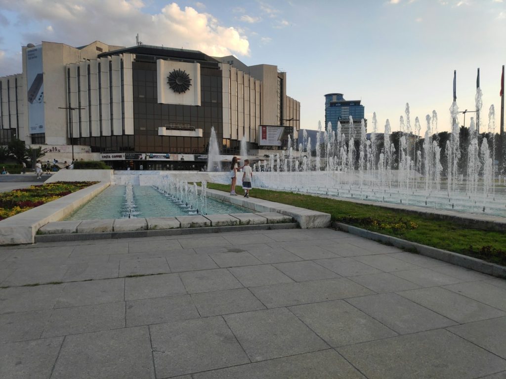 a large fountain in front of a large building
